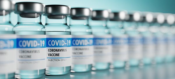 Row of Coronavirus vaccine flasks. Shallow depth of field. 3D render. 3D illustration.